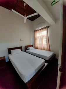two twin beds in a room with a window at Galle Serenity Bliss Private Villa in Galle +34 photos