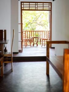 an open door to a balcony with tables and chairs at Galle Serenity Bliss Private Villa in Galle