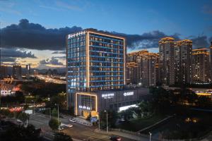 un grand bâtiment en face d'une ville la nuit dans l'établissement SSAW Boutique Hotel Wenzhou Dexin, à Wenzhou