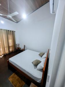 a bedroom with a bed with white sheets and pillows at Galle Serenity Bliss Private Villa in Galle