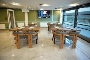 a restaurant with wooden tables and chairs and windows at Kent Room Hotel in Kapaklı