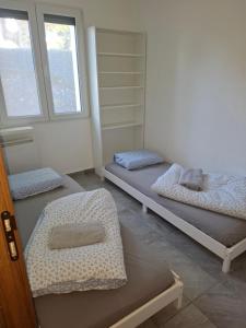 Habitación con 3 camas y 2 ventanas en Appart Dilda, en Rixheim