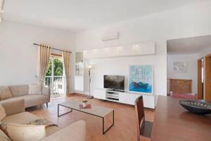 Una sala de estar con un sofá y un televisor. en Clos des Lyces, en Santa Luzia