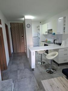 cocina con mesa y 2 taburetes en Appart Dilda, en Rixheim