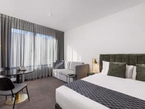 a hotel room with a bed and a couch at Mantra Tonsley Adelaide in Adelaide +125 photos
