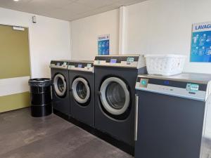 two washing machines sitting in a laundry room at ApartHotel Sainte-Marthe in Avignon