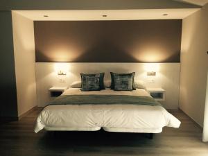1 dormitorio con 1 cama blanca grande y 2 mesas en Hotel Mirador Ría de Arosa en Reboredo