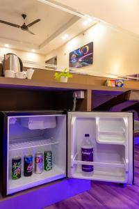 una nevera abierta con una botella de agua y refrescos en Hotel Angel Pink The Premium Rooms, en Ghaziabad
