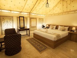 a bedroom with a bed and a chair and a desk at Marawi desert resort in Sām +128 photos