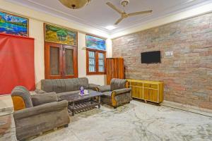sala de estar con sofás y pared de ladrillo en Hotel Angel Pink Residency Near EDM Mall, en Nueva Delhi