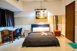 a bedroom with a bed and a table in it at Traditional Cottage at Sunway by HCK in Petaling Jaya