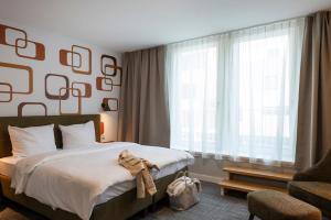 a bedroom with a bed and a large window at HUB Apartments St Georg in Hamburg