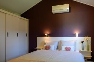 a bedroom with a large white bed with a ceiling at Chalet Charleston 069 im Heide Resort in Brüggen +6 photos