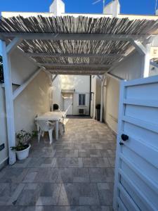 a patio with a table and a wooden roof at Alex's House Fregene in Fregene