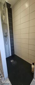 ein Bad mit einer Dusche und einem schwarzen Boden in der Unterkunft Comme à la maison in Corneville-sur-Risle + 33 Fotos