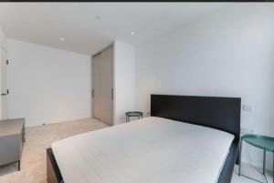 a bedroom with a bed and two green chairs at Casa Mono One Bedroom Flat in Southall