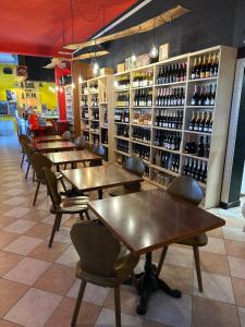 una fila de mesas y sillas en una habitación con botellas de vino en Nazìonale Minerbe, en Minerbe