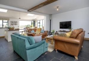 a living room with couches and chairs at Great Ash Barn in Copplestone