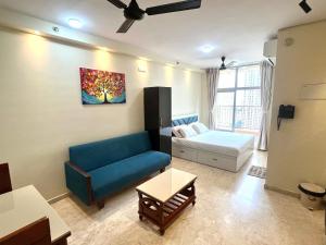 una sala de estar con un sofá y una cama en Picturesque LakeView Studio Apartment Hiranandani Estate Thane, en Thane