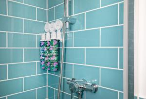 a blue tiled wall with a rack of toothbrushes at Great Ash Barn in Copplestone +34 photos