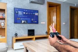 a man holding a camera in a living room with a tv at Vue mer, piscine & plage à vos pieds in Aourir