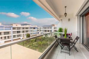 a balcony with a table and chairs and a view at Vue mer, piscine & plage à vos pieds in Aourir