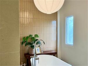 a bathroom with a tub and a potted plant at PANI Place Khaolak in Khao Lak