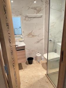 a bathroom with a shower and a toilet and a sink at Best appartement pools view at Mansouria in Pont Blondin