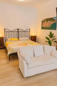 a bedroom with a bed and a white couch at Borgo nel Vigneto in Erbusco