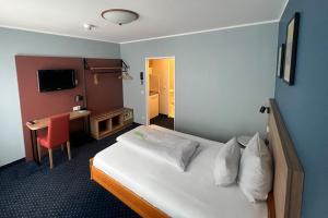 a hotel room with a bed and a desk at Garner Hotel Bochum by IHG in Bochum +113 photos