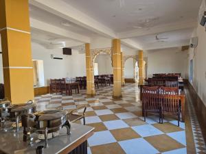 a restaurant with tables and chairs and a checkerboard floor at Shreeji Desert Resort in Sām +45 photos