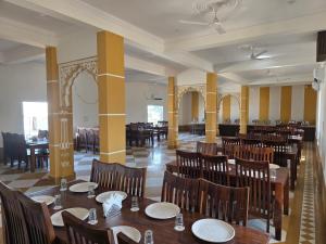 a dining room with wooden tables and chairs at Shreeji Desert Resort in Sām