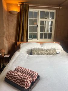 a bed with two pillows on it with a window at The Sandwich Hideaway in Sandwich
