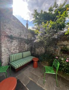 a green couch on a patio with chairs and flowers at The Sandwich Hideaway in Sandwich