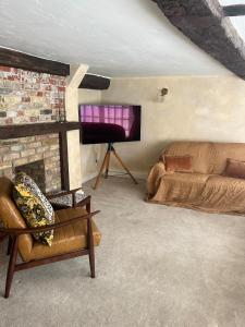 a living room with a couch and a fireplace at The Sandwich Hideaway in Sandwich