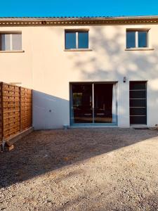 la ti breizh enchantée في Campénéac: مبنى ابيض مع بوابة وكراج