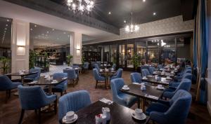 a restaurant with blue chairs and tables in a room at Ashling Hotel Dublin in Dublin