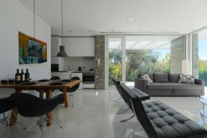 a kitchen and living room with a table and chairs at A - Luxury Villas in Plomari