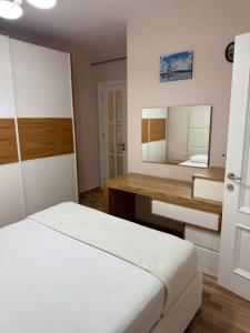 a bedroom with a bed and a desk and a mirror at Luxury Apartments in Vlorë