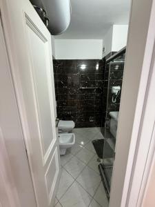 a white bathroom with a toilet and a shower at Luxury Apartments in Vlorë +11 photos