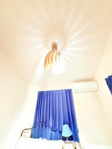 a bedroom with a ceiling fan and a blue curtain at 池袋本町302 in Tokyo