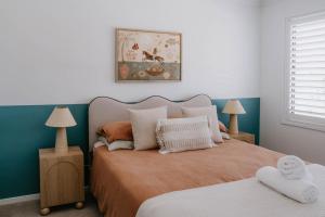 een slaapkamer met een bed en 2 tafels met lampen bij Phoenix Jervis Bay Family Coastal Escape in Vincentia