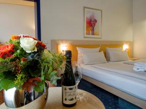 a bedroom with a bed and a table with a bottle of wine at Hotel von Euch in Meppen +24 photos