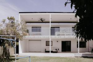 een wit huis met een grote garage bij Phoenix Jervis Bay Family Coastal Escape in Vincentia