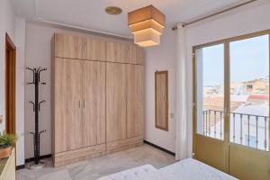 a bedroom with a large wooden cabinet and a window at Casa Filo Vistas Montaña in Rute