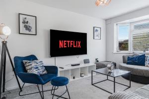 a living room with a television on a wall at Highland House in Birmingham
