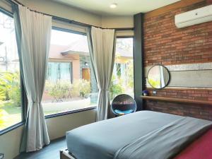 a bedroom with a bed and a large window at Cafe'@luv22 in Phuket Town