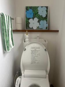 a bathroom with a toilet with a picture above it at Yotsuya Lantern - Private 3 stories house for family in Tokyo +7 photos