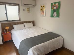a bedroom with a bed in a room with a window at Yotsuya Lantern - Private 3 stories house for family in Tokyo
