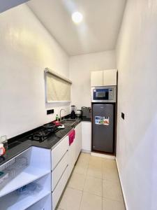 アブジャにあるND2 Luxury Apartment Jabiのキッチン(黒い冷蔵庫、白いキャビネット付)